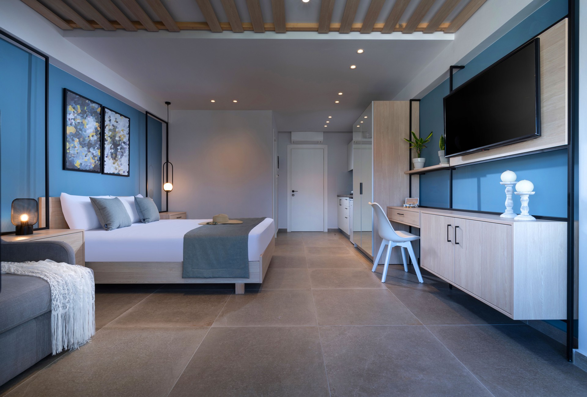 Petit studio intérieur bleu moderne avec chambre à coucher, cuisine, salon en espace unique. Appartement scandinave contemporain d’hôtel de modèle de grenier avec le mobilier blanc et en bois